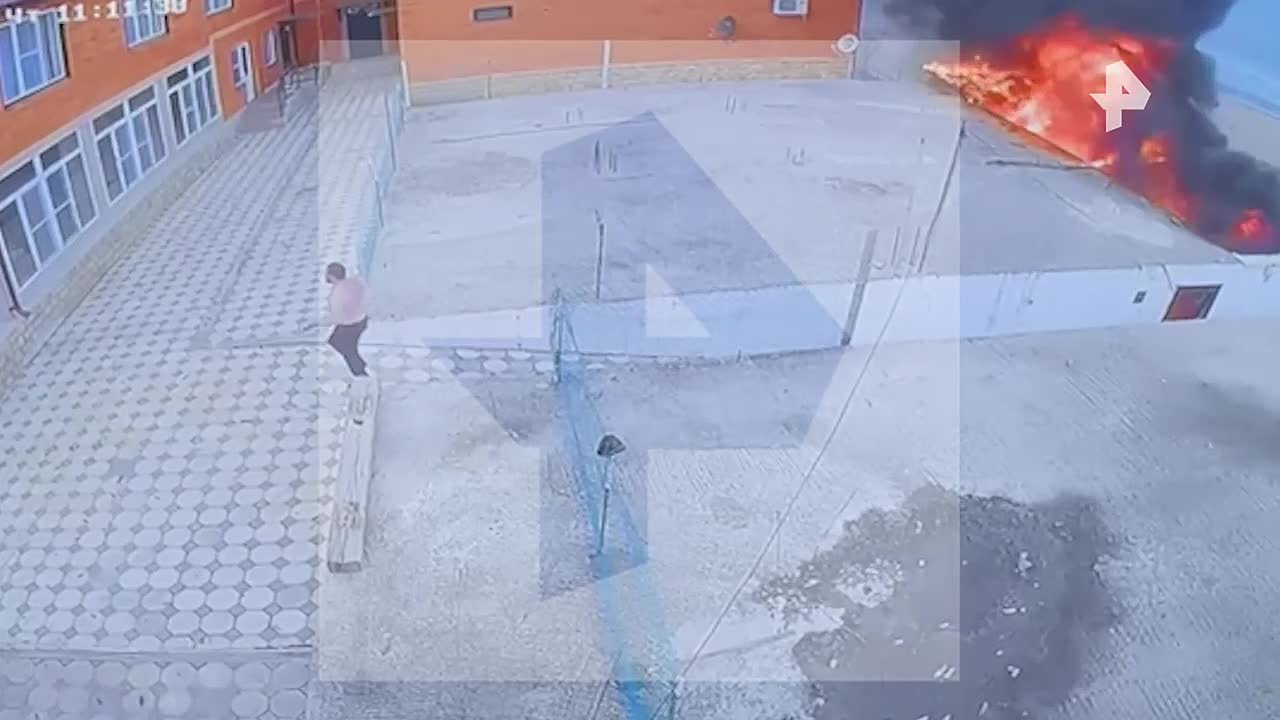 : На кадрах РЕН ТВ — момент, когда мужчина в поисках помощи обегает здание, у которого упал вертолет Ка-226 в Дагестане