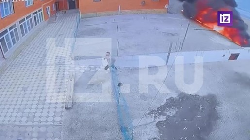 На кадрах "Известий" — момент, когда мужчина в поисках помощи обегает здание, у которого упал вертолет Ка-226 в Дагестане